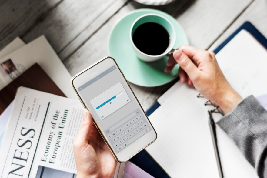 person checking news headlines on smartphone with coffee