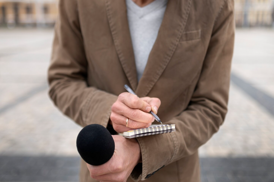 reporter taking notes with microphone, showing what does sources say mean in journalism