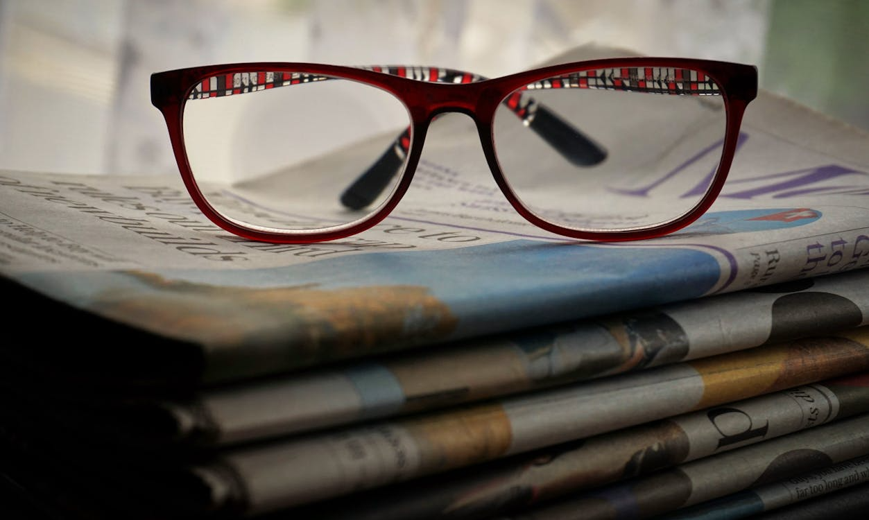 glasses resting on stacked newspapers showing why context matters in news